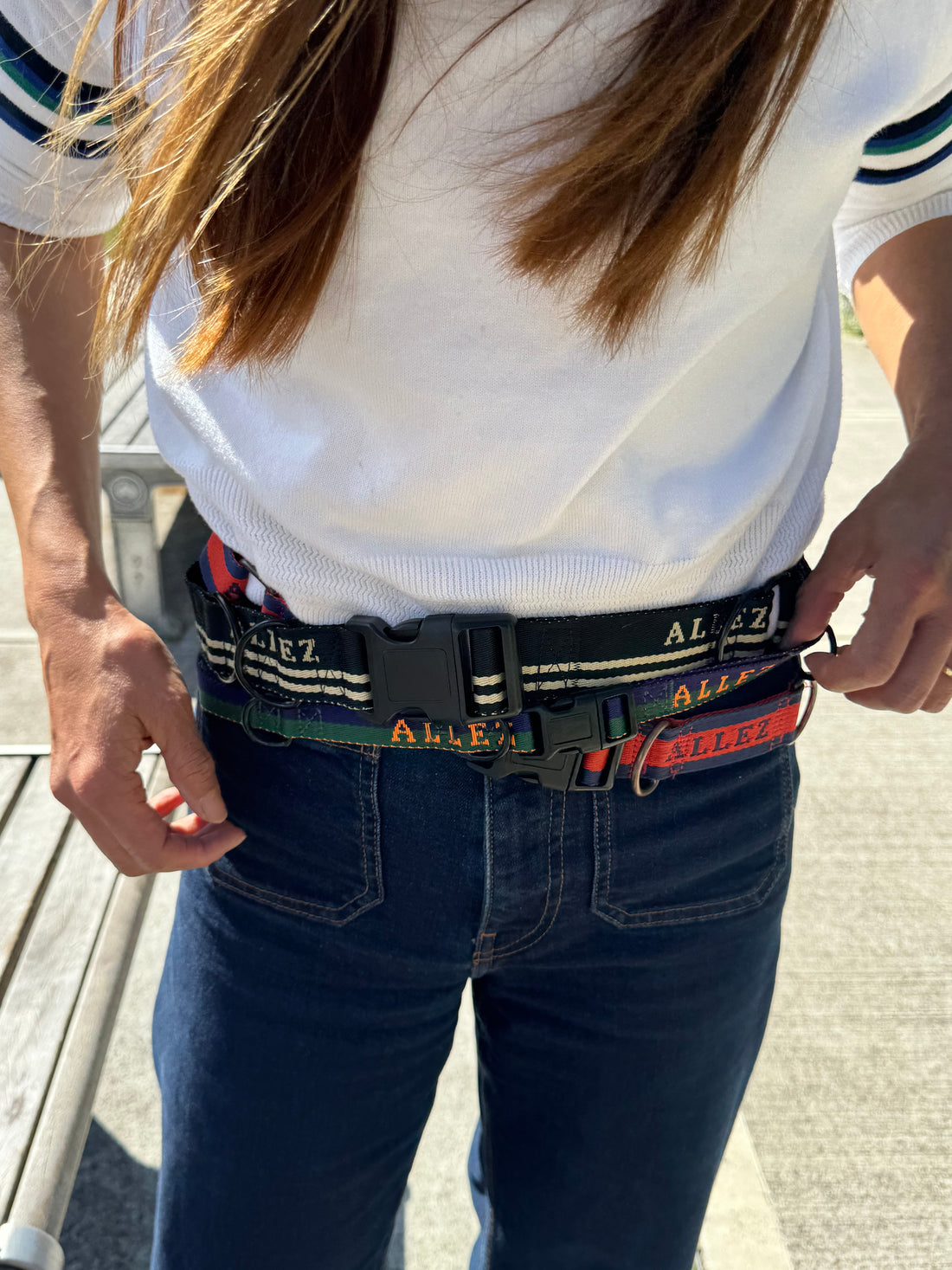 A lady wearing jeands and three Allez hands free dog belts around her waist. This shows Allez's different premium webbing styles